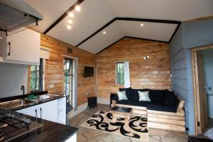un soggiorno con pareti in legno e divano di Elwai Centre Wood Cabins - Couples' hideout a Heni Village