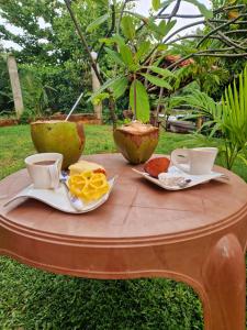 una mesa con comida y tazas encima en Nature Paradise Guesthouse, en Wayikkal