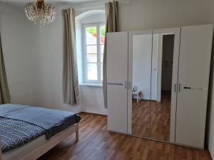 a bedroom with a bed and a glass cabinet at Traumhafter Altbau im Herzen Schwertbergs in Schwertberg