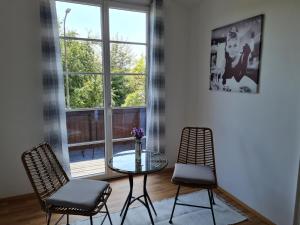 a room with a glass table and two chairs and a window at Traumhafter Altbau im Herzen Schwertbergs in Schwertberg