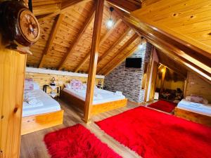 een grote kamer met 2 bedden en een televisie bij Kore Guest House in Gjirokastër