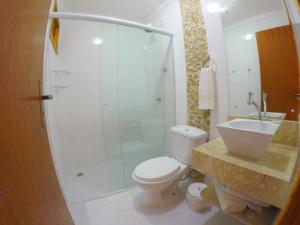 uma casa de banho com um chuveiro, um WC e um lavatório. em Pousada Magnus no Balneário Camboriú