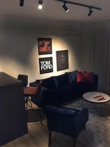 a living room with a blue couch and chairs at The Grey Apartment - Center of Prishtina in Pristina
