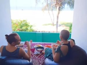 two young girls sitting on a couch eating food at Summer beach house Alleppy beach in Alleppey