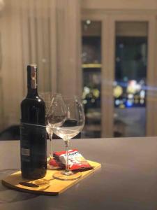 a bottle of wine and two glasses on a table at The Grey Apartment - Center of Prishtina in Pristina