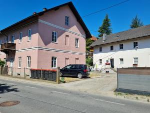 SchwertbergにあるTraumhafter Altbau im Herzen Schwertbergsのピンクの建物の前に停車する車