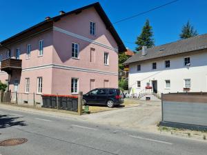 a car parked in front of a pink building at Traumhafter Altbau im Herzen Schwertbergs in Schwertberg