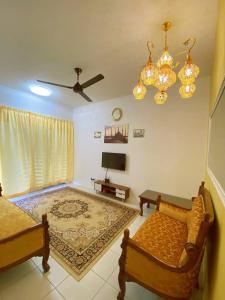 een woonkamer met 2 bedden en een televisie bij WawAmir Homestay @ Seri Iskandar in Seri Iskandar