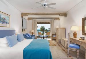 a bedroom with a bed and a desk and a couch at Columbia Beach Resort in Pissouri