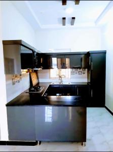 a kitchen with a black counter and a sink at Galaxy Inn Guest House in Karachi