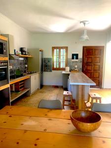 a large kitchen with a wooden table and a counter at Pangea Corfu Villa in Sidari