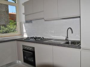 a white kitchen with a sink and a stove at Apartment Brezza di Mare by Interhome in Formia