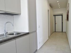 a kitchen with white cabinets and a sink and a hallway at Apartment Brezza di Mare by Interhome in Formia