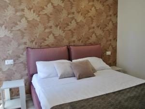 a bedroom with a white bed with a pink headboard at Apartment Brezza di Mare by Interhome in Formia +4 photos
