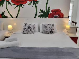 a bedroom with a white bed with red flowers on the wall at Gem of Manor drive in Durban