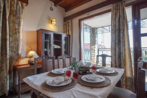 a dining room with a table and a large window at SaffronStays The Perch in Kasauli