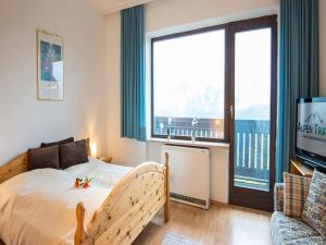 een slaapkamer met een bed en een groot raam bij Apartment Landhaus St- Georg-5 by Interhome in Bad Gastein