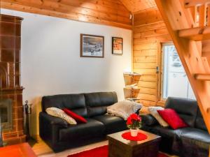 a living room with a black leather couch and a fireplace at Holiday Home Lampitaival 6b by Interhome in Kotila