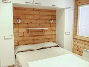a bedroom with a wooden accent wall and a bed at Holiday Home Lampitaival 6b by Interhome in Kotila