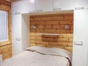 a bedroom with a wooden wall with a bed at Holiday Home Lampitaival 6b by Interhome in Kotila +10 photos