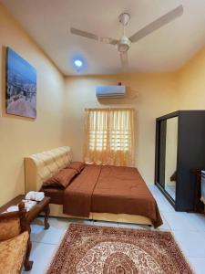 1 dormitorio con 1 cama y ventilador de techo en WawAmir Homestay @ Seri Iskandar en Seri Iskandar