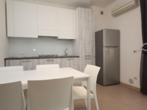 a kitchen with a table and chairs and a refrigerator at Apartment Veranda-6 by Interhome in Rosapineta +14 photos