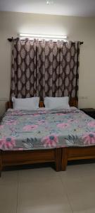 a bedroom with a bed with a large headboard at Brookside Service Apartment in Bangalore
