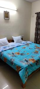 a bedroom with a bed with a blue comforter at Brookside Service Apartment in Bangalore