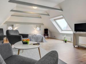 uma sala de estar com um sofá e cadeiras e uma televisão em Holiday Home Gabija - all inclusive - in Western Jutland by Interhome em Højer