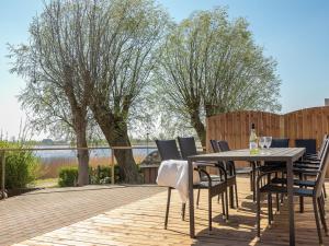 een tafel en stoelen op een terras met uitzicht op een meer bij Holiday Home Gabija - all inclusive - in Western Jutland by Interhome in Højer