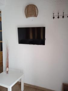 sala de estar con TV en una pared blanca en Casa Venus en Sabinosa
