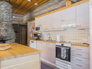 eine Küche mit weißen Schränken und einer Arbeitsplatte in der Unterkunft Holiday Home Kiilopään maja by Interhome in Saariselkä