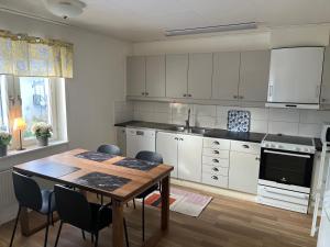 a kitchen with a wooden table and a dining room at Uppsala Lägenhetshotell in Uppsala