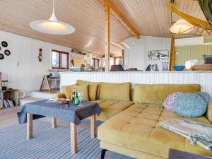 ein Wohnzimmer mit einem Sofa und einem Tisch in der Unterkunft Holiday Home Geeske - 150m from the sea in Funen by Interhome in Middelfart