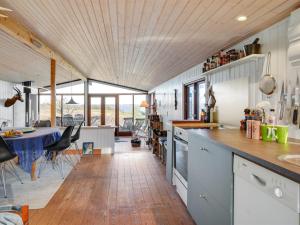 een keuken en een woonkamer met een tafel en stoelen bij Holiday Home Geeske - 150m from the sea in Funen by Interhome in Middelfart