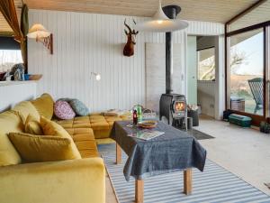 een woonkamer met een bank en een houtkachel bij Holiday Home Geeske - 150m from the sea in Funen by Interhome in Middelfart