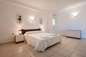 1 dormitorio blanco con 1 cama y 2 mesitas de noche en Villa Carola - PlusHolidays, en Calpe