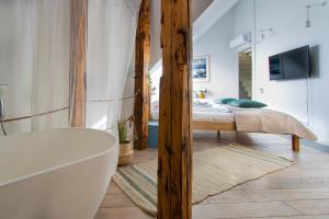 a bathroom with a tub and a bedroom with a bed at Duplex apartment in the center of Krakow in Krakow