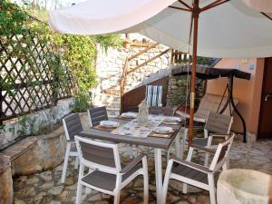 una mesa y sillas bajo una sombrilla en un patio en Holiday Home Sirenetta by Interhome, en Sperlonga