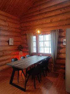een eetkamer met een tafel in een blokhut bij Riverside Villa in Rovaniemi