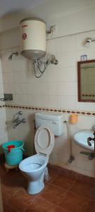 a bathroom with a toilet and a sink at Brookside Service Apartment in Bangalore
