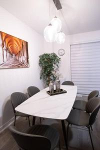 une salle à manger avec une table et des chaises blanches dans l'établissement Flipped House - entire 2 BR townhouse near wonderland, à Vaughan