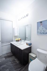 a bathroom with a sink and a toilet and a mirror at Flipped House - entire 2 BR townhouse near wonderland in Vaughan