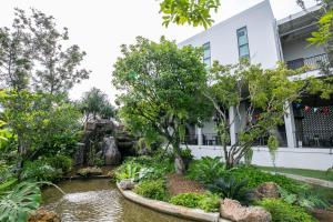 a garden in front of a building at Chainam-Charmchuree residences cafe and spa in Ban Bang Bua Thong