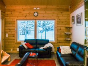 a living room with leather furniture and a large window at Holiday Home Lampitaival 6a by Interhome in Kotila