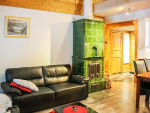 a living room with a leather couch and a wood stove at Holiday Home Lampitaival 6a by Interhome in Kotila