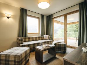 - un salon avec un canapé et une table dans l'établissement Apartment Wulfenia Lodge 4 Raum IN2 by Interhome, à Sonnenalpe Nassfeld