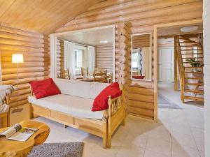 una sala de estar con sofá en una cabaña de madera en Holiday Home Ilotupa by Interhome, en Pertunmaa