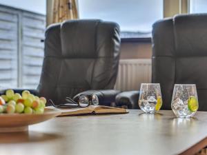 - une table avec des verres, un livre et un bol de fruits dans l'établissement Apartment Els - 100m to the inlet in Western Jutland by Interhome, à Hvide Sande
