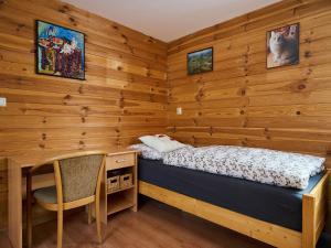 a bedroom with a bed and a desk and a chair at Holiday Home Chaloupka U lesa by Interhome in Harrachov